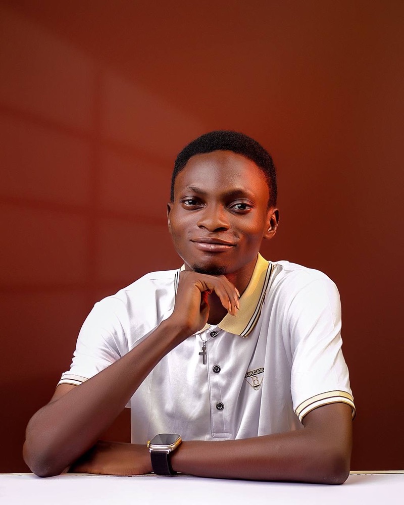Joseph Ajibomode, marketing automation and AI agents expert, smiling with his chin resting on his hand
